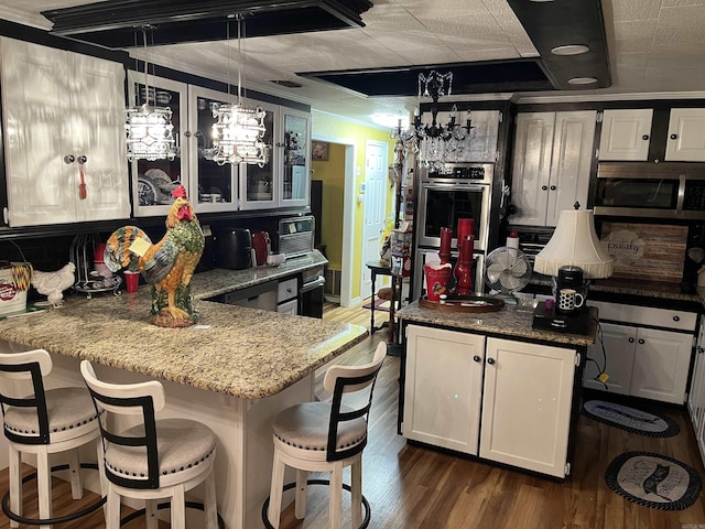 kitchen with a peninsula, glass insert cabinets, white cabinets, and dark wood-style flooring