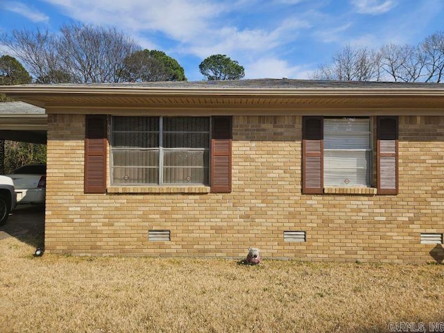 view of property exterior featuring a yard, brick siding, and crawl space