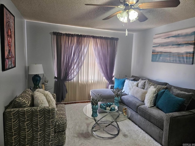 living area featuring ceiling fan and a textured ceiling