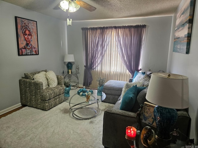 interior space with ceiling fan, a textured ceiling, and baseboards