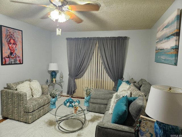 sitting room with carpet, ceiling fan, a textured ceiling, and baseboards