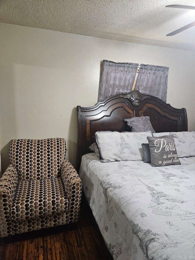 bedroom with a textured ceiling and wood finished floors