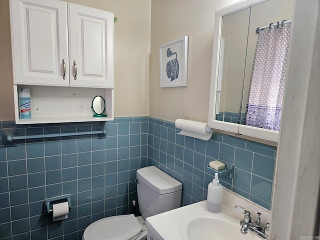 bathroom featuring wainscoting, a sink, and toilet