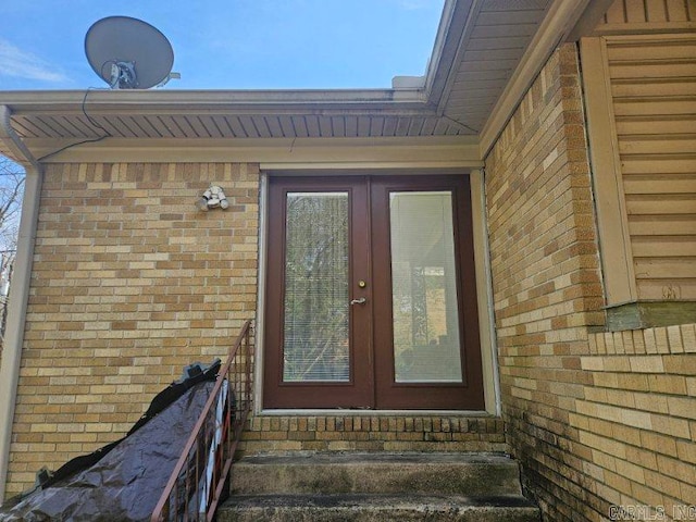 entrance to property featuring brick siding and french doors