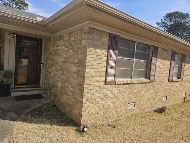 view of side of home with brick siding and crawl space