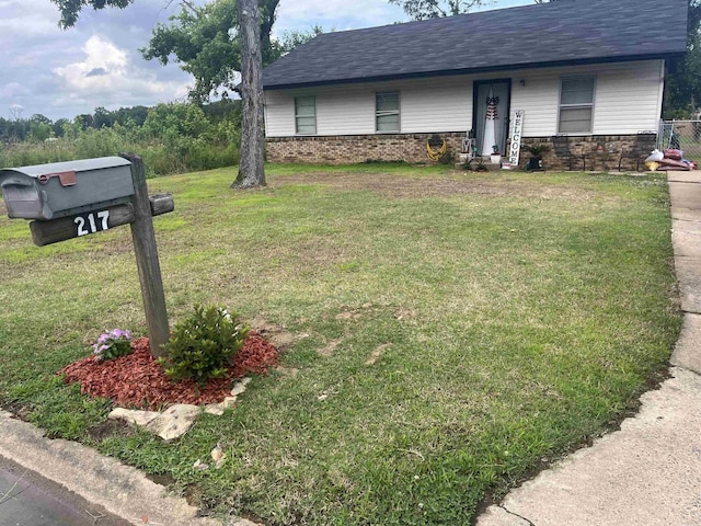 view of front of home with a shingled roof and a front yard