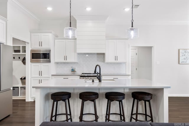 kitchen featuring stainless steel appliances, dark wood finished floors, light countertops, and a sink