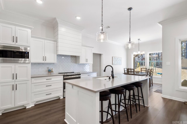 kitchen featuring stainless steel appliances, crown molding, a sink, and decorative backsplash