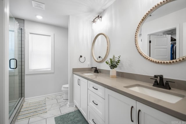 bathroom featuring toilet, marble finish floor, a shower stall, and a sink