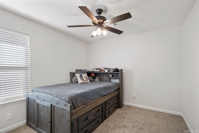 bedroom with light colored carpet, ceiling fan, and baseboards