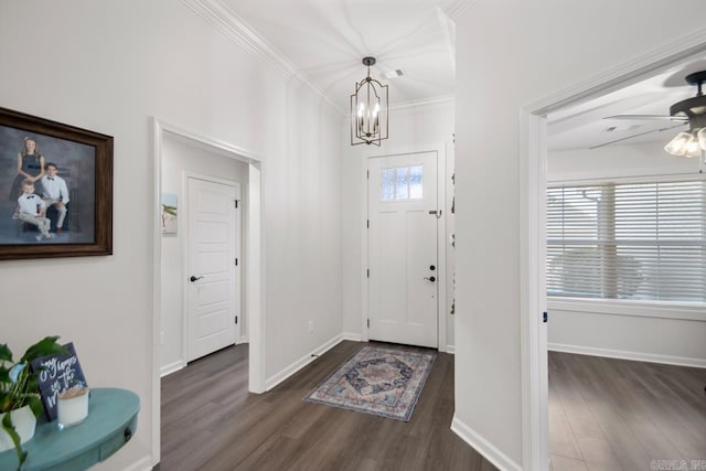 foyer featuring baseboards, ornamental molding, dark wood-style flooring, and ceiling fan with notable chandelier