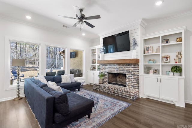 living room featuring ceiling fan, dark wood-style flooring, crown molding, a fireplace, and recessed lighting