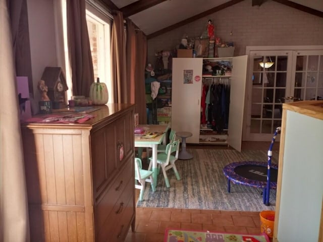 interior space with lofted ceiling with beams, french doors, and a closet