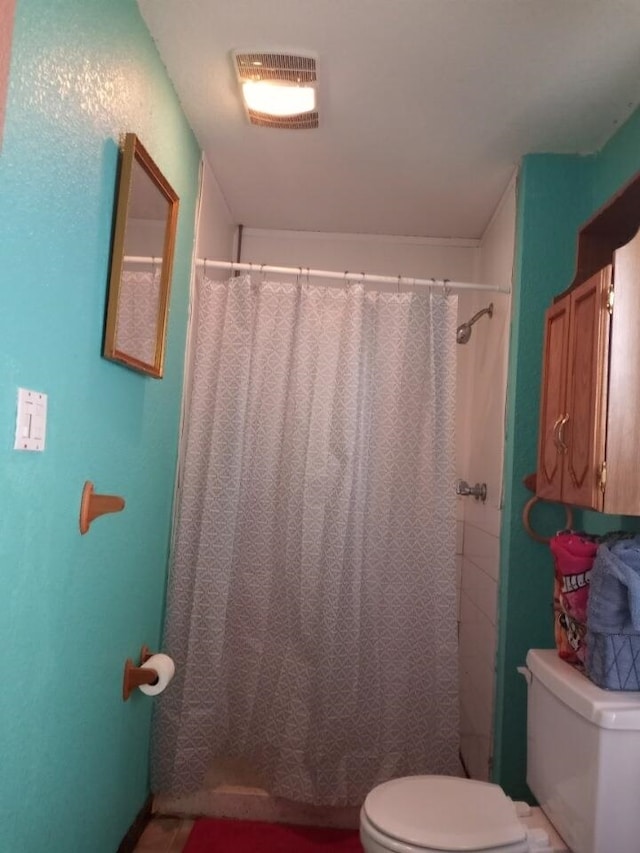 bathroom featuring toilet, curtained shower, and visible vents