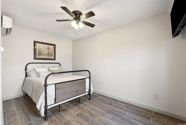 bedroom with wood tiled floor, ceiling fan, baseboards, and a wall mounted AC