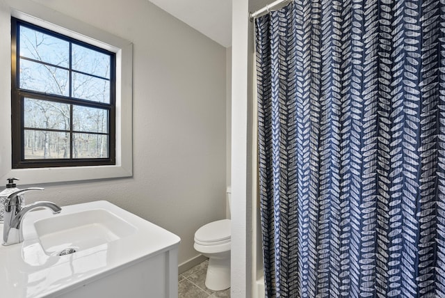 bathroom featuring a shower with curtain, a sink, toilet, and tile patterned floors