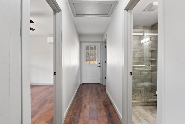 hall featuring attic access, baseboards, and wood finished floors