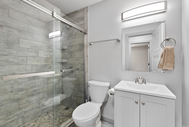 bathroom with a stall shower, vanity, and toilet