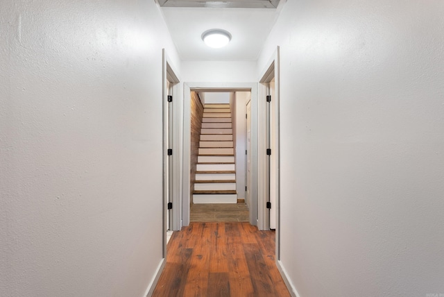 hallway featuring stairway, baseboards, and wood finished floors