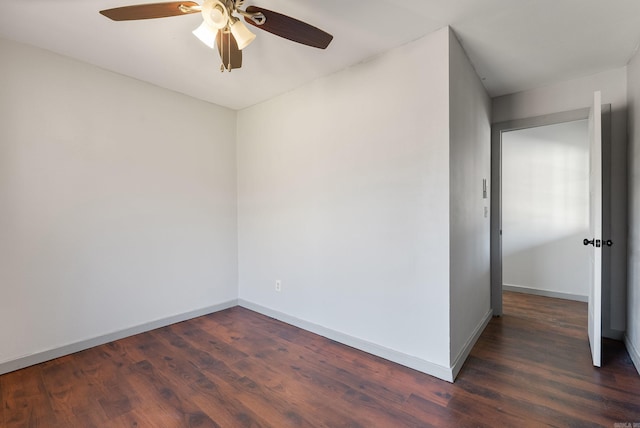 spare room with dark wood-style floors, baseboards, and a ceiling fan