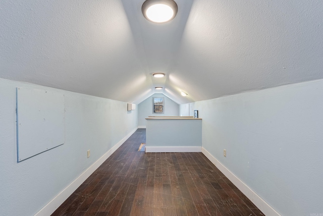 bonus room featuring a textured ceiling, wood-type flooring, and baseboards