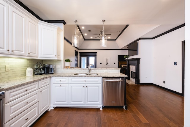 kitchen featuring a peninsula, dishwasher, ornamental molding, and a sink