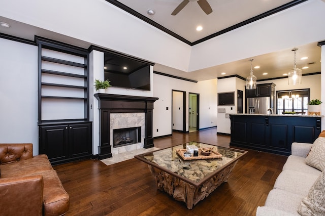 living room featuring ornamental molding, baseboards, dark wood-style floors, and a premium fireplace