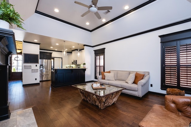 living area with baseboards, visible vents, a ceiling fan, ornamental molding, and dark wood-style flooring