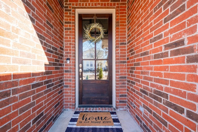 doorway to property with brick siding