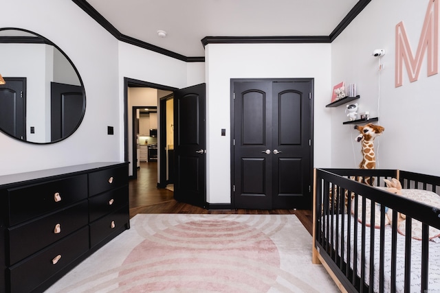 bedroom featuring ornamental molding, a closet, and wood finished floors