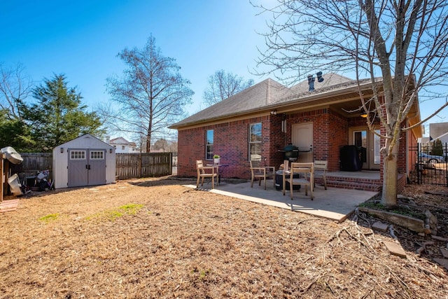 back of property featuring an outbuilding, brick siding, a storage shed, a patio area, and a fenced backyard