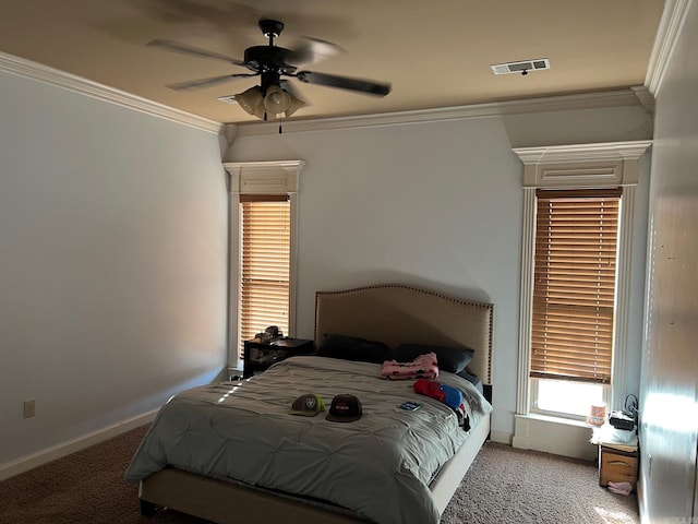 carpeted bedroom featuring baseboards, visible vents, ceiling fan, and crown molding