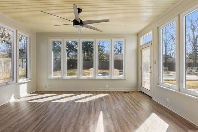 unfurnished sunroom featuring a ceiling fan, visible vents, and plenty of natural light