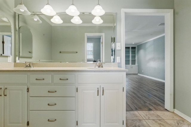 full bathroom featuring a sink, double vanity, baseboards, and crown molding