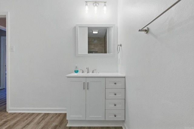 bathroom featuring wood finished floors, vanity, and baseboards