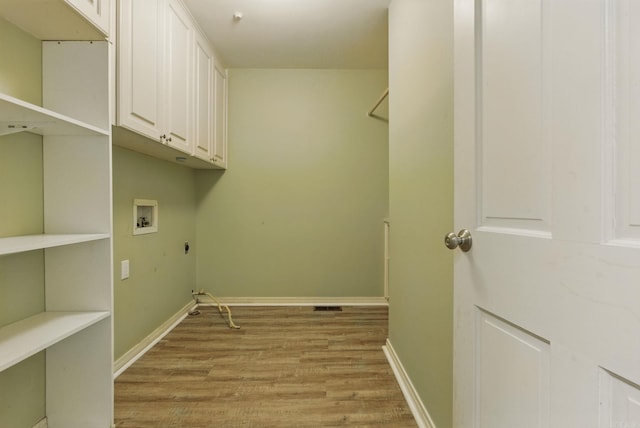 laundry area featuring cabinet space, light wood finished floors, baseboards, hookup for a washing machine, and electric dryer hookup