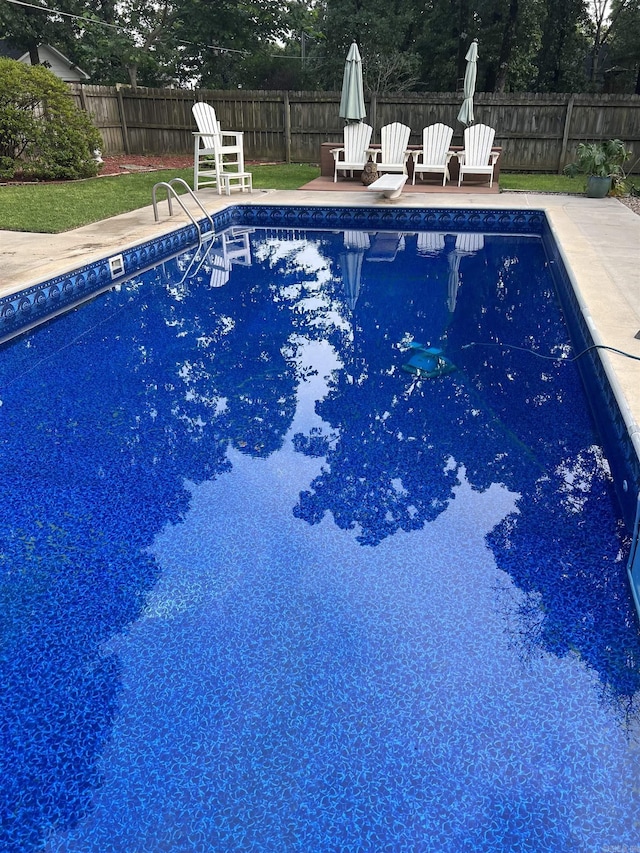 view of pool featuring a diving board, a patio area, a fenced backyard, and a fenced in pool