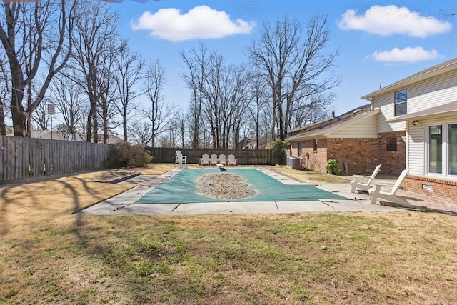 view of swimming pool with a fenced in pool, cooling unit, a fenced backyard, and a yard