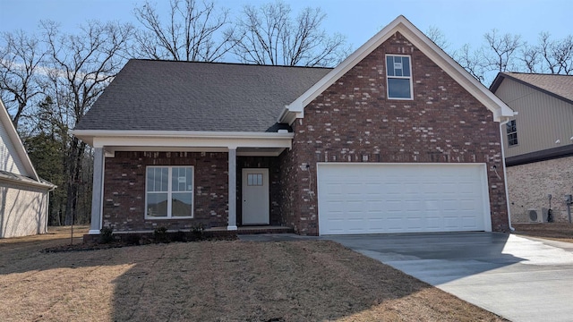 traditional-style home featuring a garage, driveway, brick siding, and roof with shingles