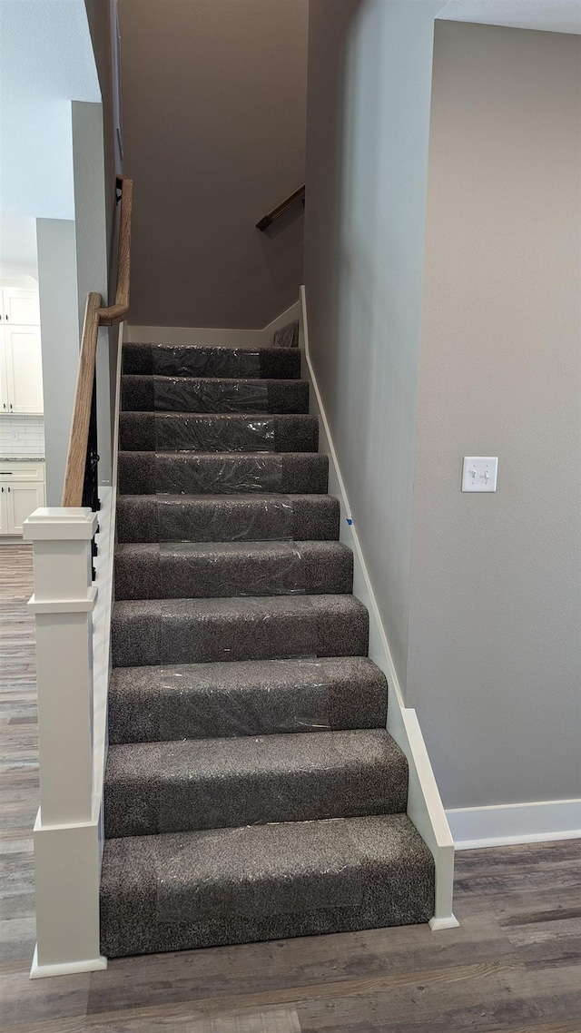 stairs featuring baseboards and wood finished floors