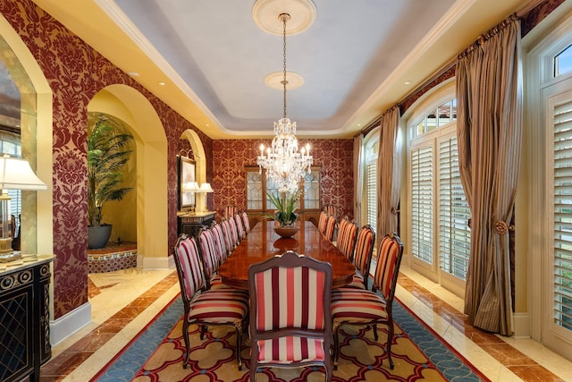 dining area featuring wallpapered walls, baseboards, a raised ceiling, and an inviting chandelier