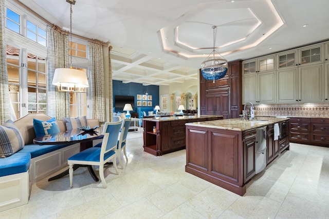 kitchen with decorative light fixtures, coffered ceiling, a sink, open floor plan, and a center island with sink