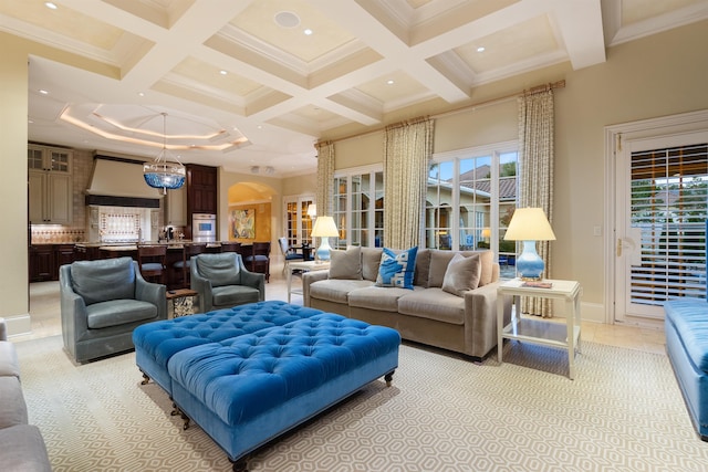 living area with arched walkways, coffered ceiling, beam ceiling, and ornamental molding