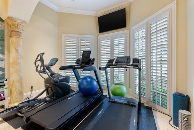 exercise room with ornamental molding and baseboards