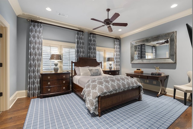 bedroom with baseboards, visible vents, crown molding, and wood finished floors