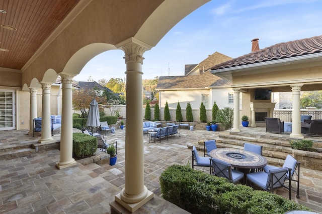 view of patio / terrace featuring an outdoor living space with a fireplace and fence