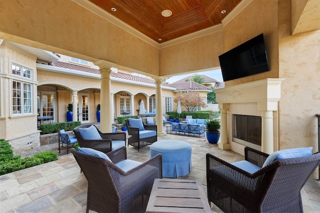 view of patio / terrace featuring an outdoor living space with a fireplace and french doors