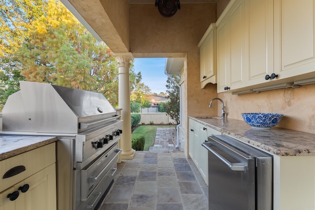 view of patio / terrace featuring exterior kitchen, a grill, fence, and a sink