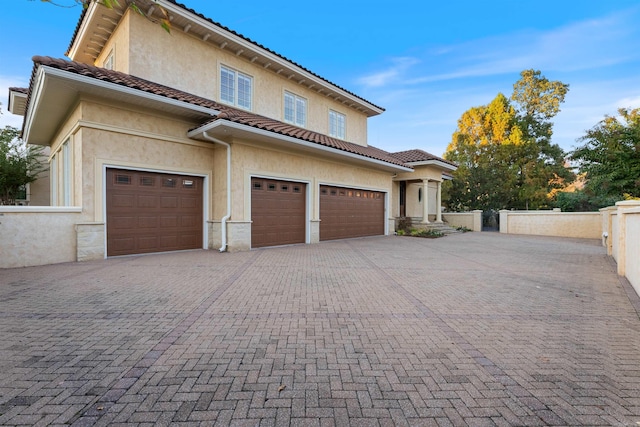 view of front of home featuring a garage, decorative driveway, and stucco siding