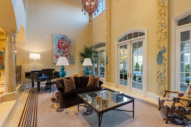 interior space with baseboards, french doors, a healthy amount of sunlight, and ornate columns